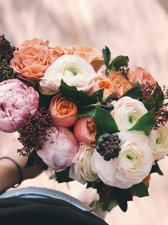 A colorful bridal bouquet featuring roses and peonies, perfect for weddings.